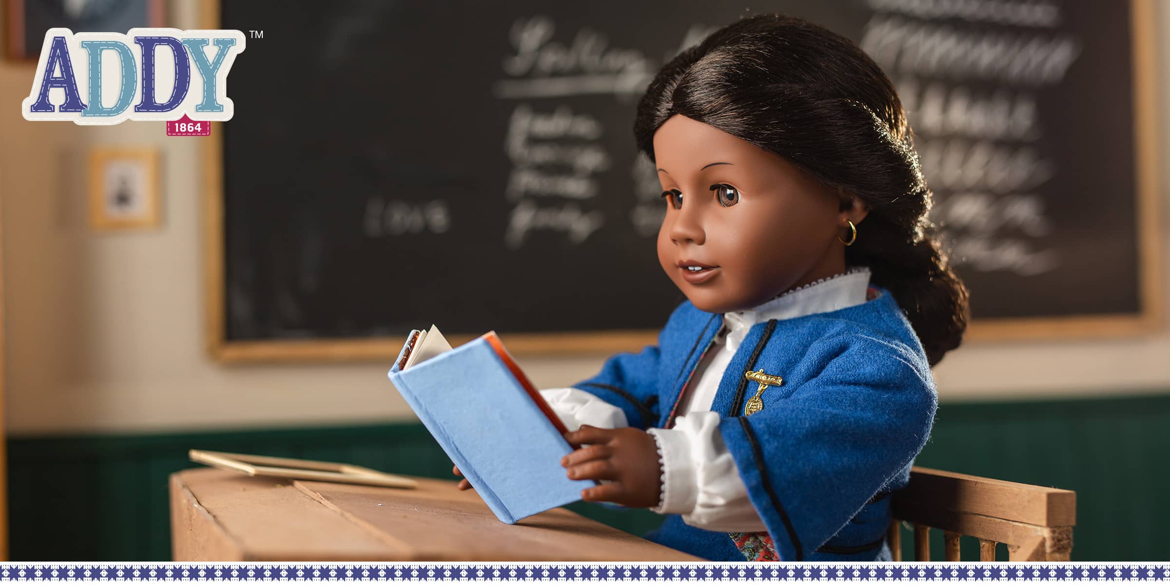 Addy Walker doll reading a book in her school classroom
